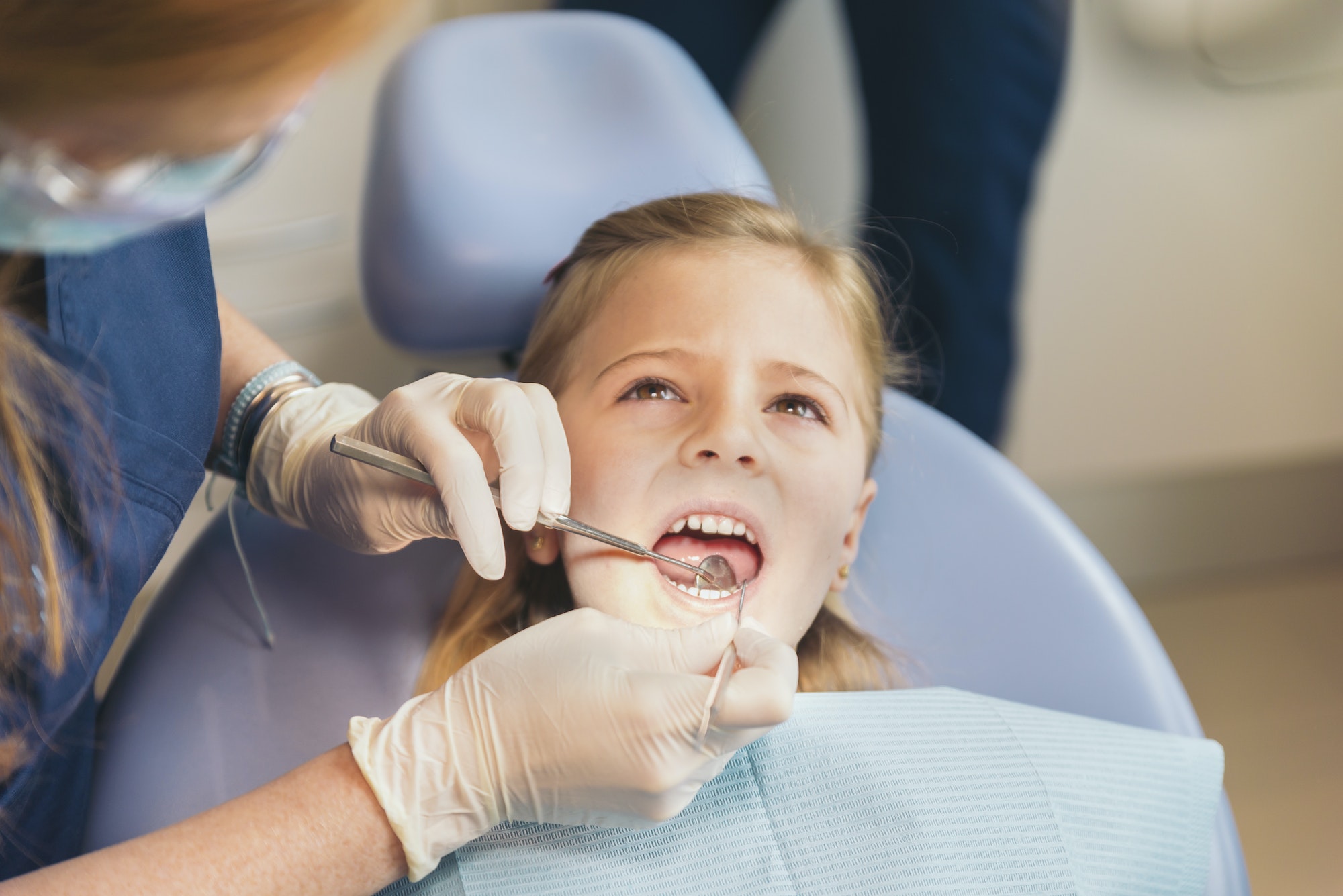 Dentists with a patient during a dental intervention to girl. Dentists with a patient during a dental intervention to girl.
